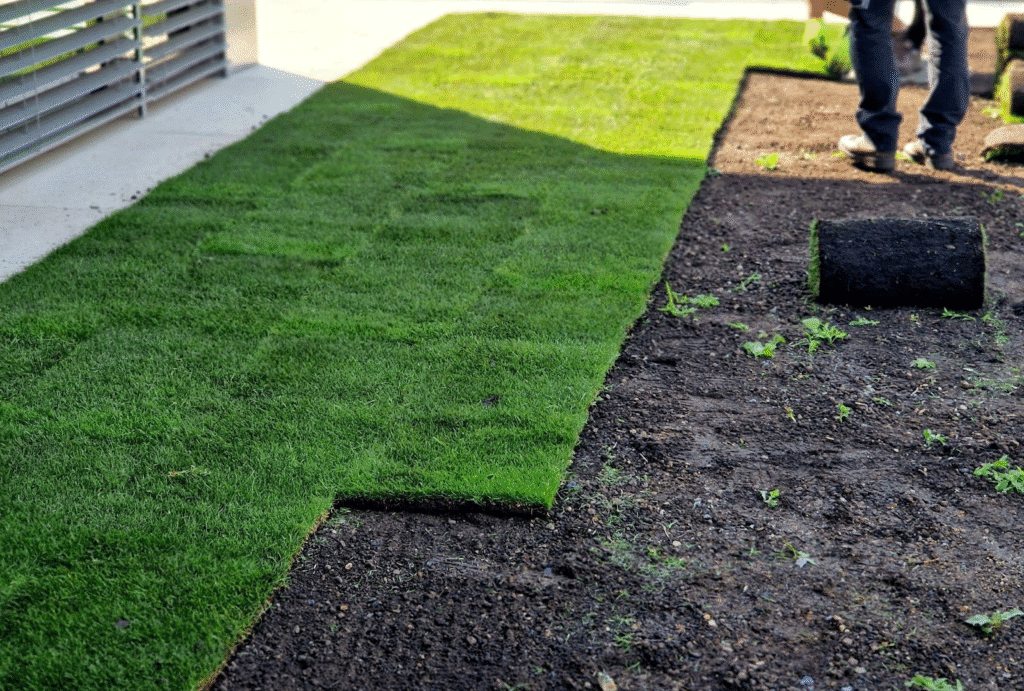 A man lays artificial grass ensuring a visually appealing lawn